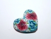 Une perle forme coeur en polymère, motif fleuri bleu rose
