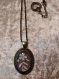 Collier chaîne courte. cabochon en dentelle sous verre. décoré en métal antique.