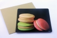 Carte postale « macarons » illustrée de 3 macarons beige, rose et vert sur fond noir
