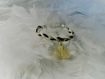 Bracelet tressé tricolore noir, gris et ivoire avec pompon beige 
