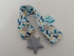 Attache-tétine en tissus à motifs géométriques bleus, gris et jaunes avec pression et attache type bretelle étoile grise 