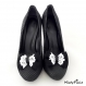 Clips chaussure noeud noir avec dentelle blanche.